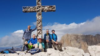 Dolomiten – Teilnehmer auf dem Gipfelkreuz
